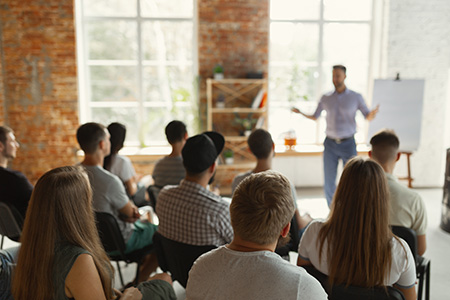 Someone leading a meeting with a blank pad on an easel