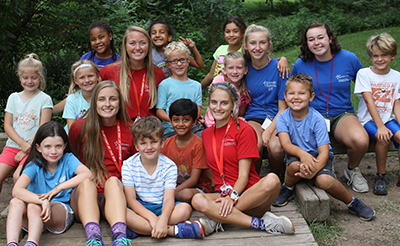 Kids and adults posing for a photo at a previous Playcamp